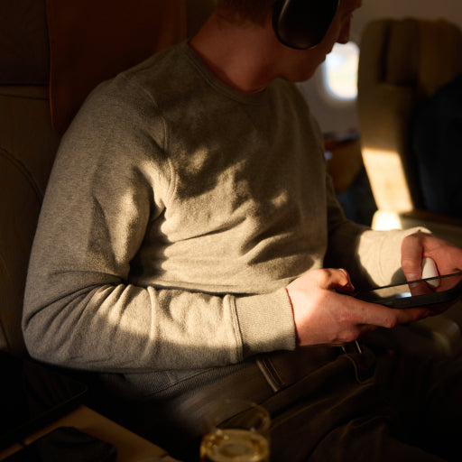 Man wearing ACE Sweatshirt while on a plane