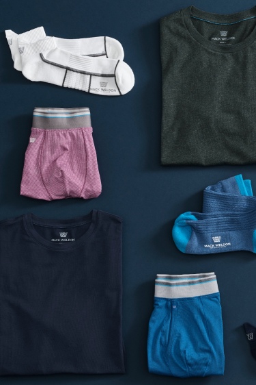 birds-eye view of Mack Weldon clothing laid out on a navy blue ground