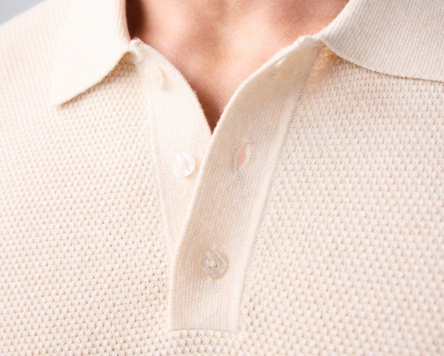 close up image of the collar of a cream tech linen polo